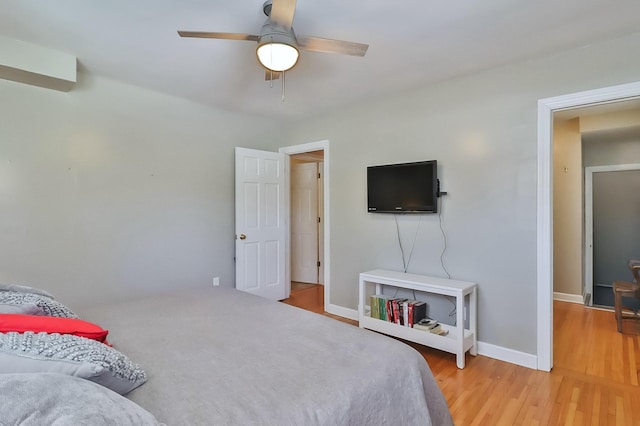 bedroom with ceiling fan, light wood-type flooring, and baseboards