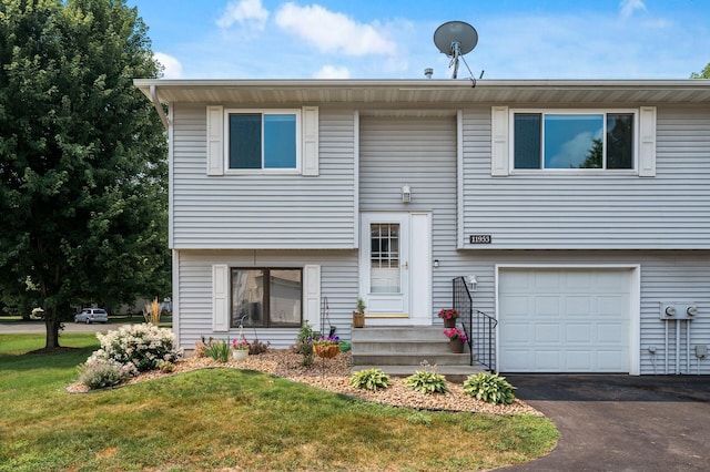 split foyer home featuring aphalt driveway, a front yard, and a garage