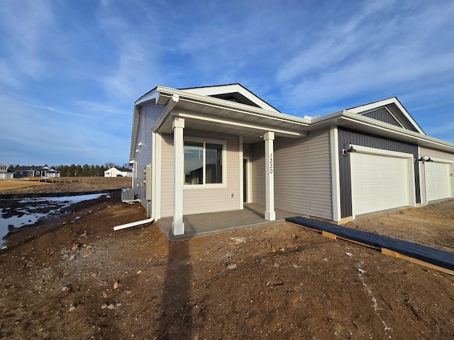 view of front of property featuring cooling unit and a garage