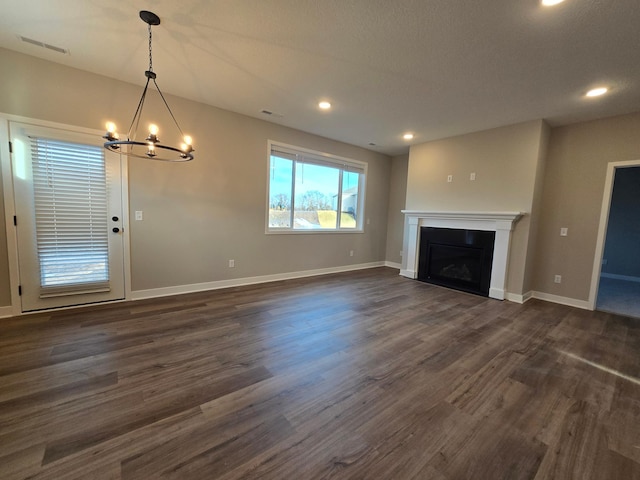 unfurnished living room with visible vents, baseboards, dark wood-style floors, and a fireplace