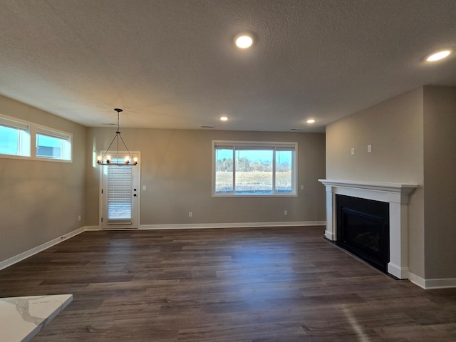 unfurnished living room featuring dark wood-style floors, a healthy amount of sunlight, and a fireplace