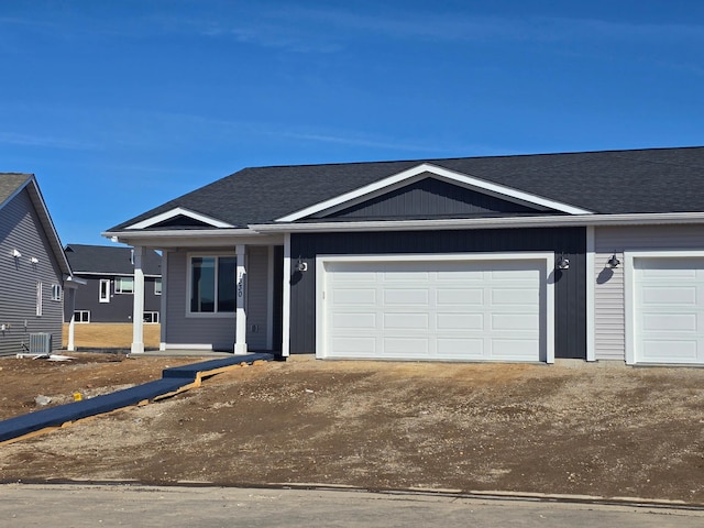 view of front facade with a garage, roof with shingles, and driveway