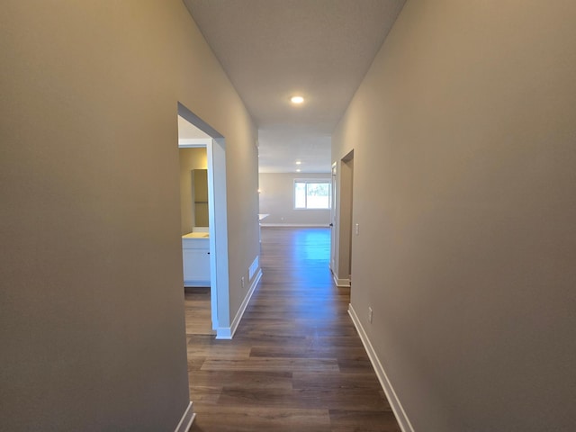 hallway with baseboards and dark wood-type flooring