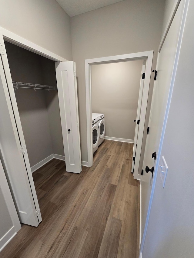 washroom featuring laundry area, wood finished floors, independent washer and dryer, and baseboards