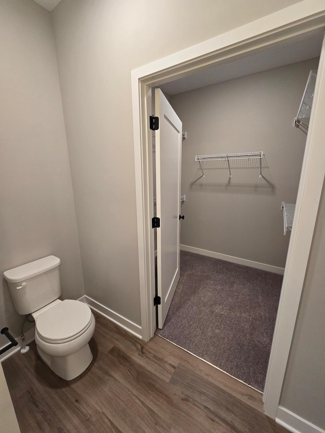 bathroom featuring baseboards, toilet, and wood finished floors