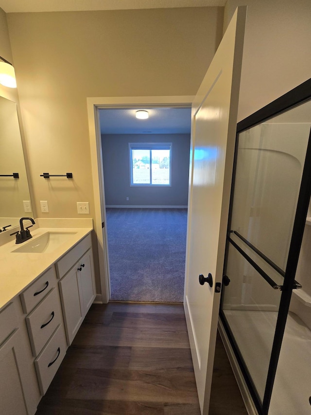 bathroom featuring vanity, wood finished floors, and baseboards