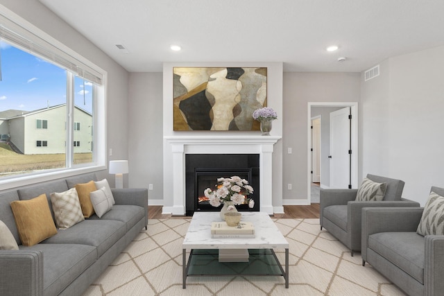 1330 Rose St, New Richmond, WI 54017 - living room with light wood finished floors, a lit fireplace, recessed lighting, and baseboards