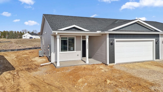 1330 Rose St, New Richmond, WI 54017 - view of front of home with central air condition unit, a shingled roof, and an attached garage