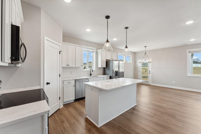 1330 Rose St, New Richmond, WI 54017 - kitchen with stainless steel appliances, a sink, white cabinets, and recessed lighting