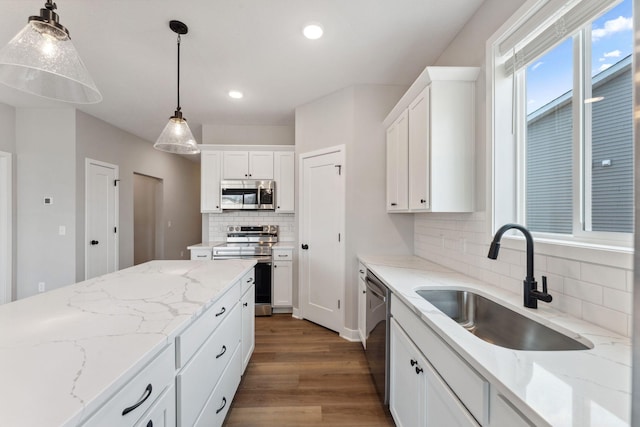 1330 Rose St, New Richmond, WI 54017 - kitchen with stainless steel appliances, a sink, wood finished floors, decorative backsplash, and white cabinetry