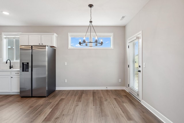 1330 Rose St, New Richmond, WI 54017 - kitchen with stainless steel fridge with ice dispenser, a chandelier, a sink, and wood finished floors