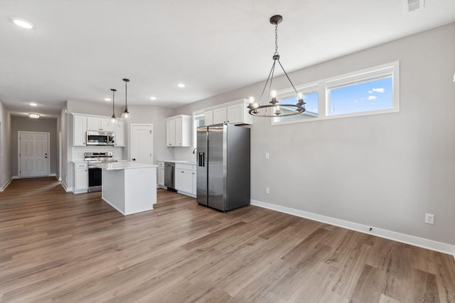 1330 Rose St, New Richmond, WI 54017 - kitchen with appliances with stainless steel finishes, a chandelier, light countertops, white cabinets, and baseboards