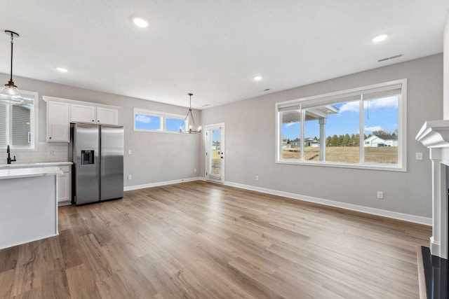 1330 Rose St, New Richmond, WI 54017 - kitchen featuring stainless steel refrigerator with ice dispenser, light countertops, a chandelier, light wood-type flooring, and recessed lighting