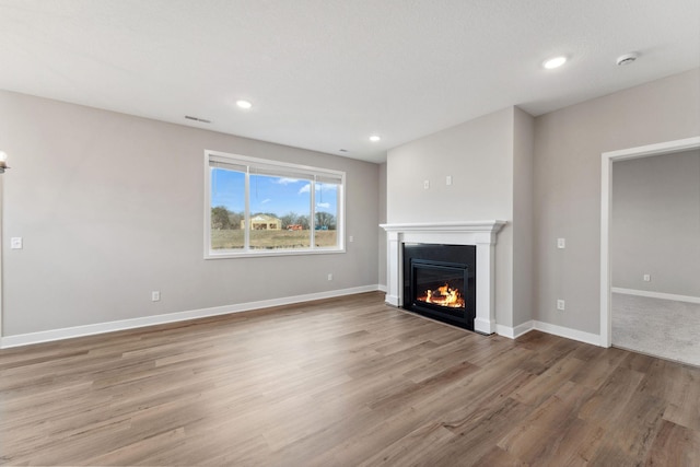 1330 Rose St, New Richmond, WI 54017 - unfurnished living room with a glass covered fireplace, wood finished floors, baseboards, and recessed lighting