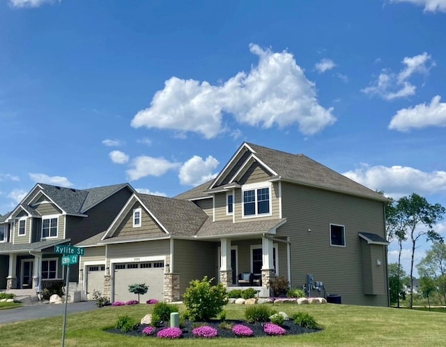 craftsman house featuring aphalt driveway, a porch, a front yard, and an attached garage