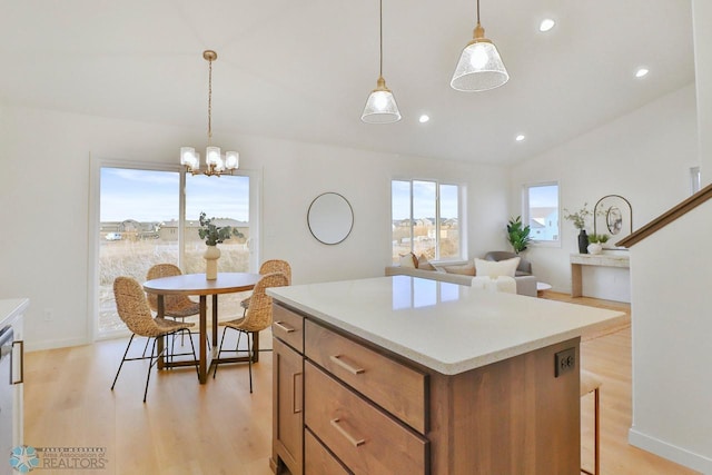 kitchen featuring vaulted ceiling, brown cabinetry, light wood finished floors, and a center island