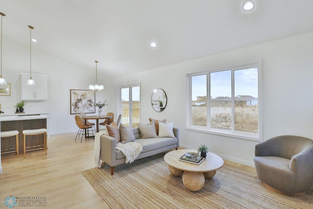 living area featuring recessed lighting, light wood-type flooring, a healthy amount of sunlight, and vaulted ceiling