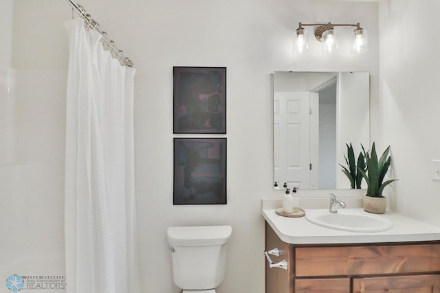 bathroom with curtained shower, toilet, and vanity