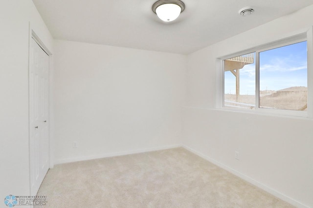 unfurnished room featuring baseboards and light colored carpet