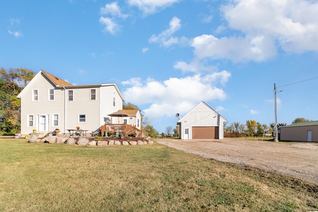 exterior space with an outbuilding, a garage, a deck, and a yard