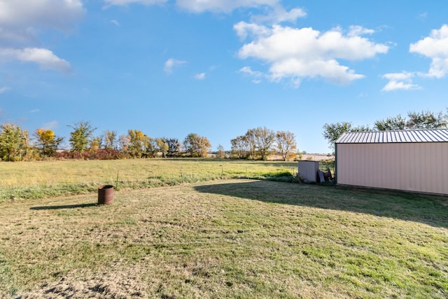 view of yard with an outbuilding, a pole building, and a rural view