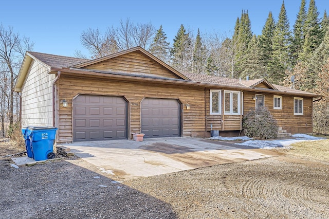 ranch-style home with concrete driveway and an attached garage