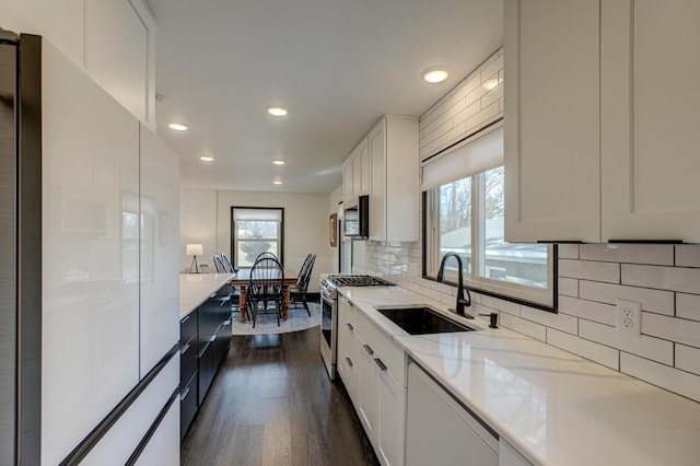 1109 Saint Croix Hts, Hudson, WI 54016 - kitchen featuring appliances with stainless steel finishes, a sink, dark wood finished floors, decorative backsplash, and light stone counters