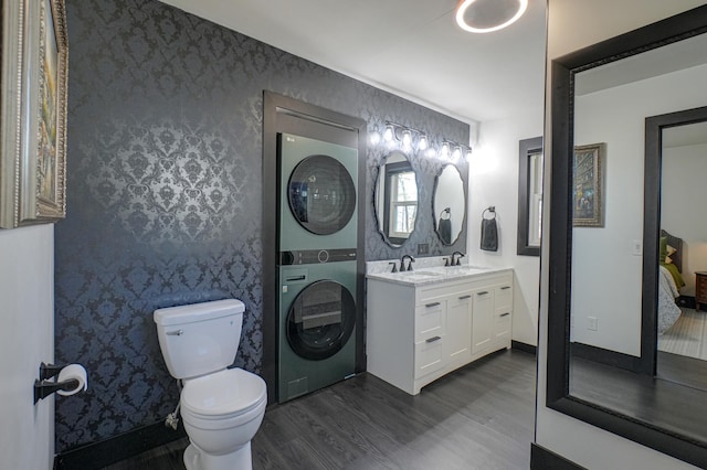 1109 Saint Croix Hts, Hudson, WI 54016 - full bath featuring estacked washer and dryer, wood finished floors, wallpapered walls, double vanity, and toilet