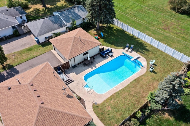 view of pool featuring a patio area, a diving board, a fenced in pool, a fenced backyard, and a lawn