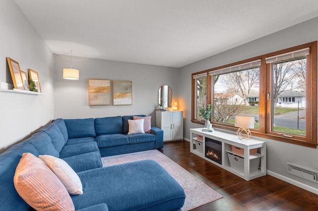 living room featuring baseboards, visible vents, and dark wood-style flooring