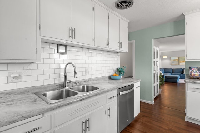 kitchen featuring light countertops, stainless steel dishwasher, backsplash, and a sink