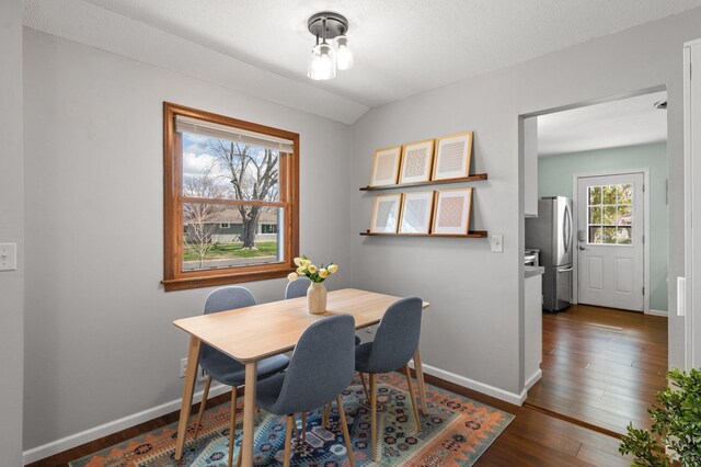 dining area with dark wood-type flooring and baseboards