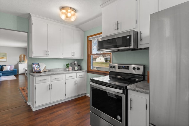 kitchen with stainless steel appliances, light countertops, white cabinets, and dark wood finished floors