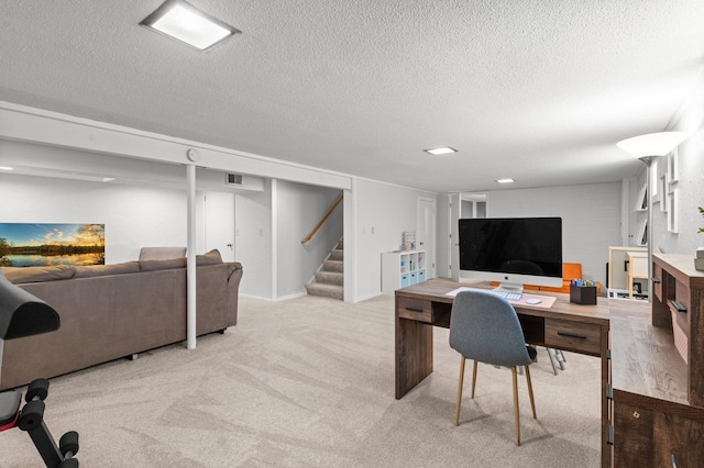 office area with a textured ceiling, visible vents, and light carpet
