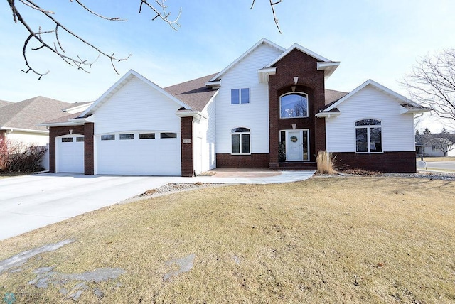 traditional-style house featuring a garage, a front yard, brick siding, and driveway