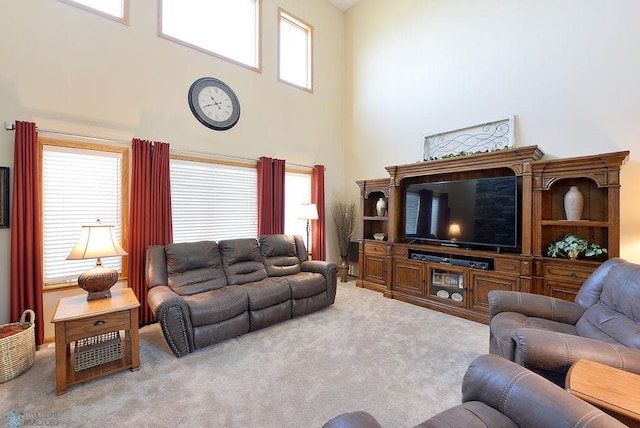 living room featuring carpet flooring and a towering ceiling