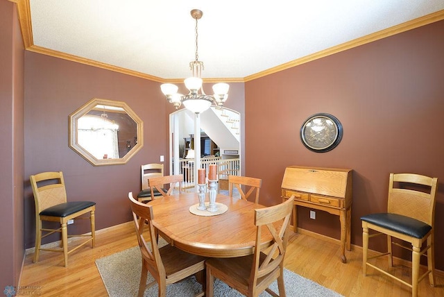 dining space featuring light wood-style flooring, baseboards, ornamental molding, and a chandelier