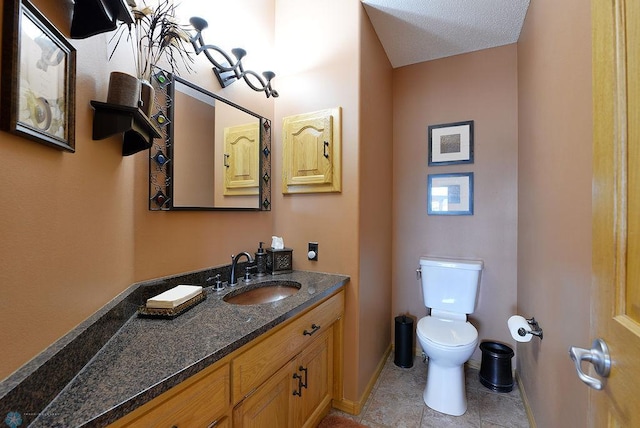 bathroom with vanity, toilet, and baseboards