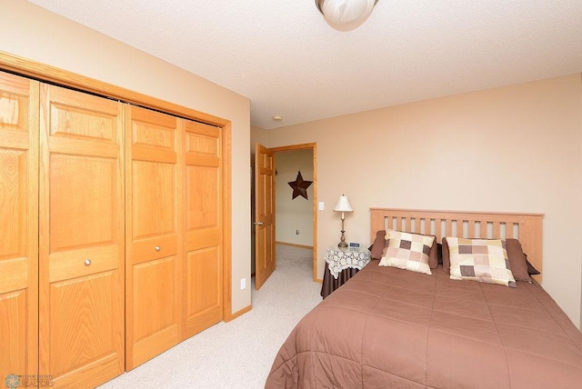 bedroom featuring a closet, baseboards, a textured ceiling, and carpet