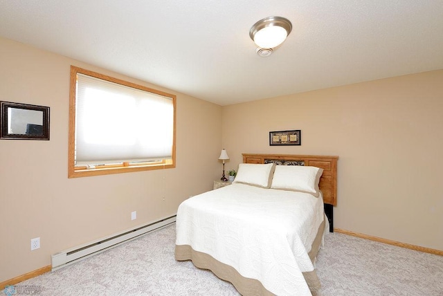 bedroom featuring light colored carpet, a baseboard heating unit, and baseboards