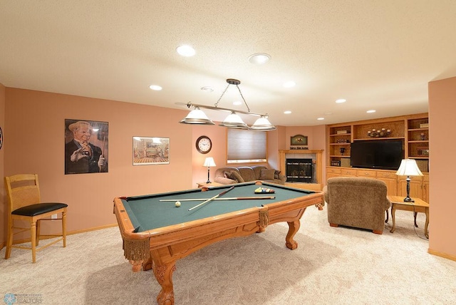 playroom with a textured ceiling, a fireplace, baseboards, and light carpet