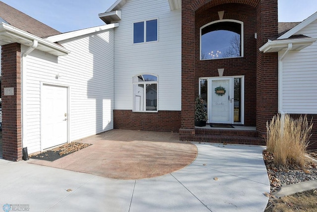 doorway to property with brick siding