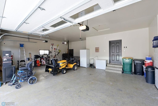 garage featuring a garage door opener and freestanding refrigerator