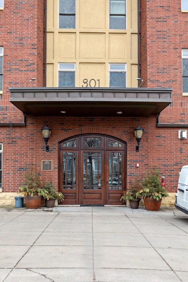 property entrance featuring french doors and brick siding