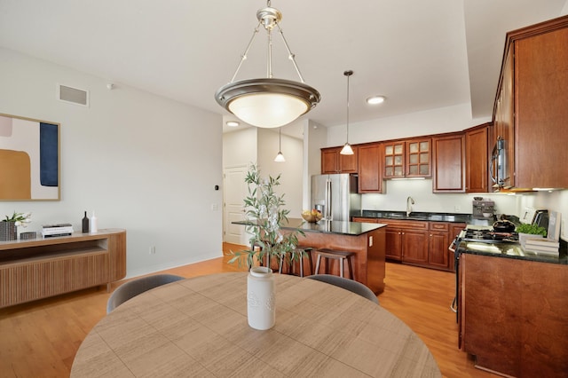 kitchen featuring a sink, dark countertops, visible vents, and stainless steel appliances