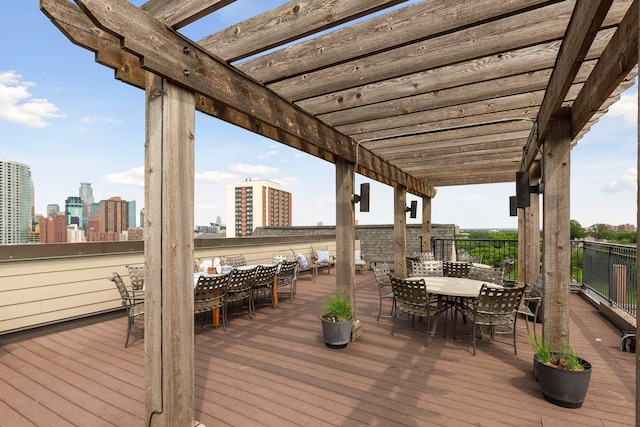 wooden deck featuring a view of city, a pergola, and outdoor dining area