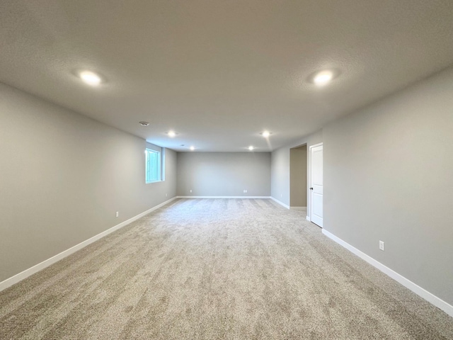 below grade area featuring recessed lighting, light colored carpet, and baseboards