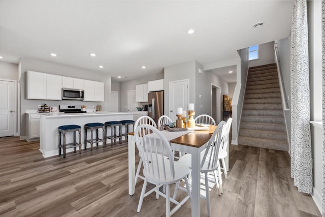 dining area featuring stairs, recessed lighting, and light wood-style floors