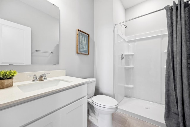 bathroom with vanity, toilet, and a stall shower