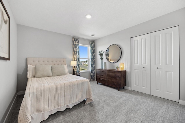 carpeted bedroom with baseboards and a closet